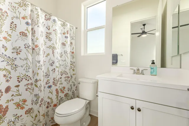 a spacious bedroom with a bed a window and a chandelier