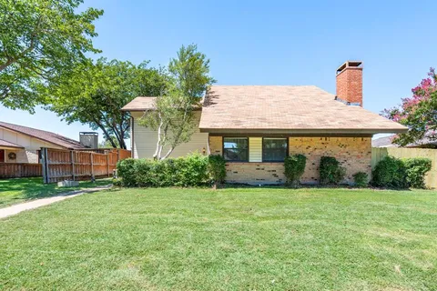 a front view of a house with a garden and yard