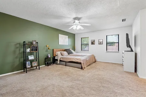 a bedroom with a large bed and a chandelier