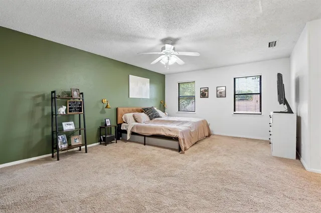a bedroom with a large bed and a chandelier