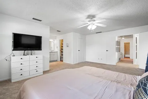 a spacious bedroom with a bed a chandelier and a window