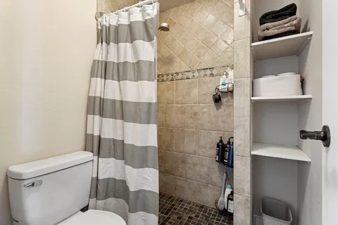 a spacious bedroom with a large bed a chandelier and closet