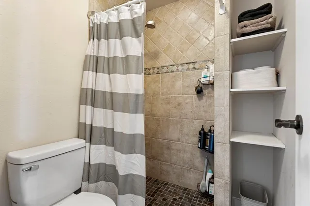 a spacious bedroom with a large bed a chandelier and closet