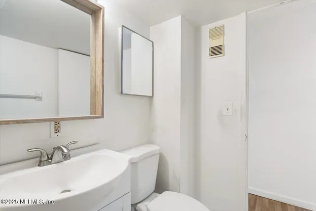 a bathroom with a sink a toilet and mirror