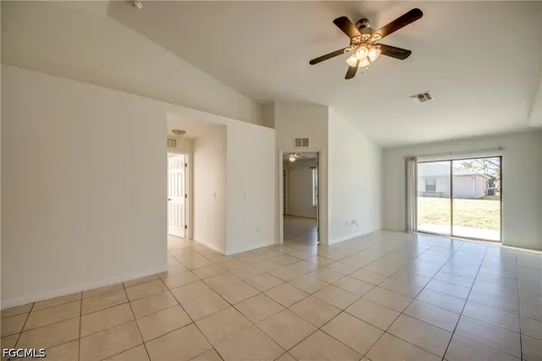a view of an empty room and window a ceiling fan
