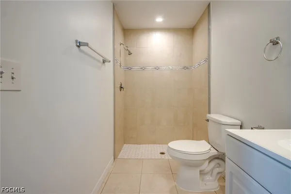 an empty room with windows and ceiling fan