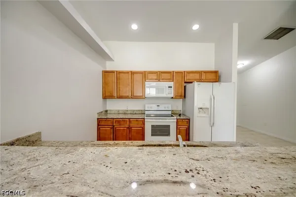 a kitchen with stainless steel appliances granite countertop a stove a sink and a refrigerator