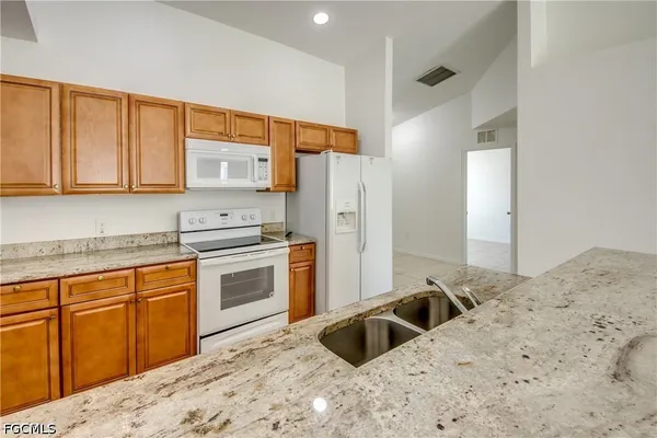 a kitchen with a stove a sink and a refrigerator