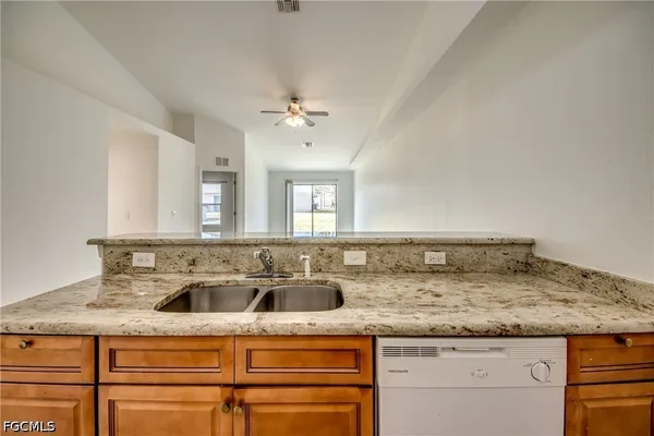 a kitchen with granite countertop a sink and a white cabinets