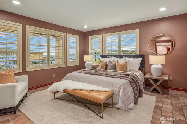 a bedroom with a bed mirror and a large window