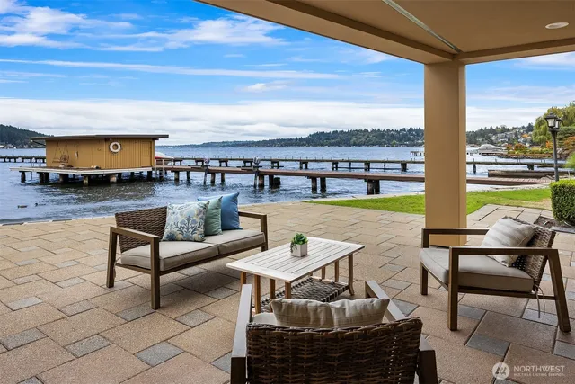 a living room with couches chairs and a floor to ceiling window with outer view