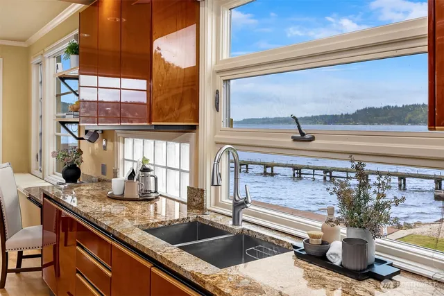 a kitchen sink with granite countertop a view of living room
