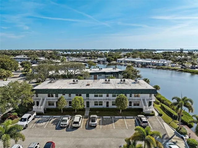 an aerial view of a building with lake view and mountain view in back