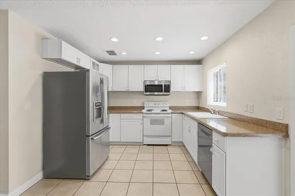 a kitchen with a sink a refrigerator and cabinets