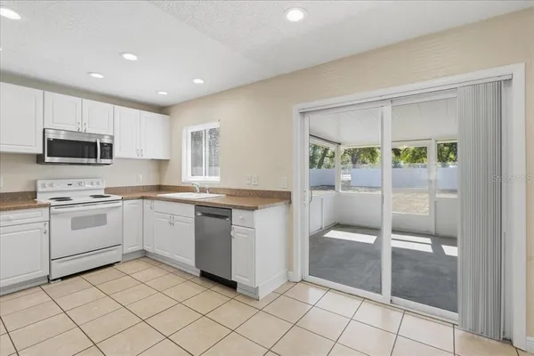 a kitchen with a refrigerator and white cabinets