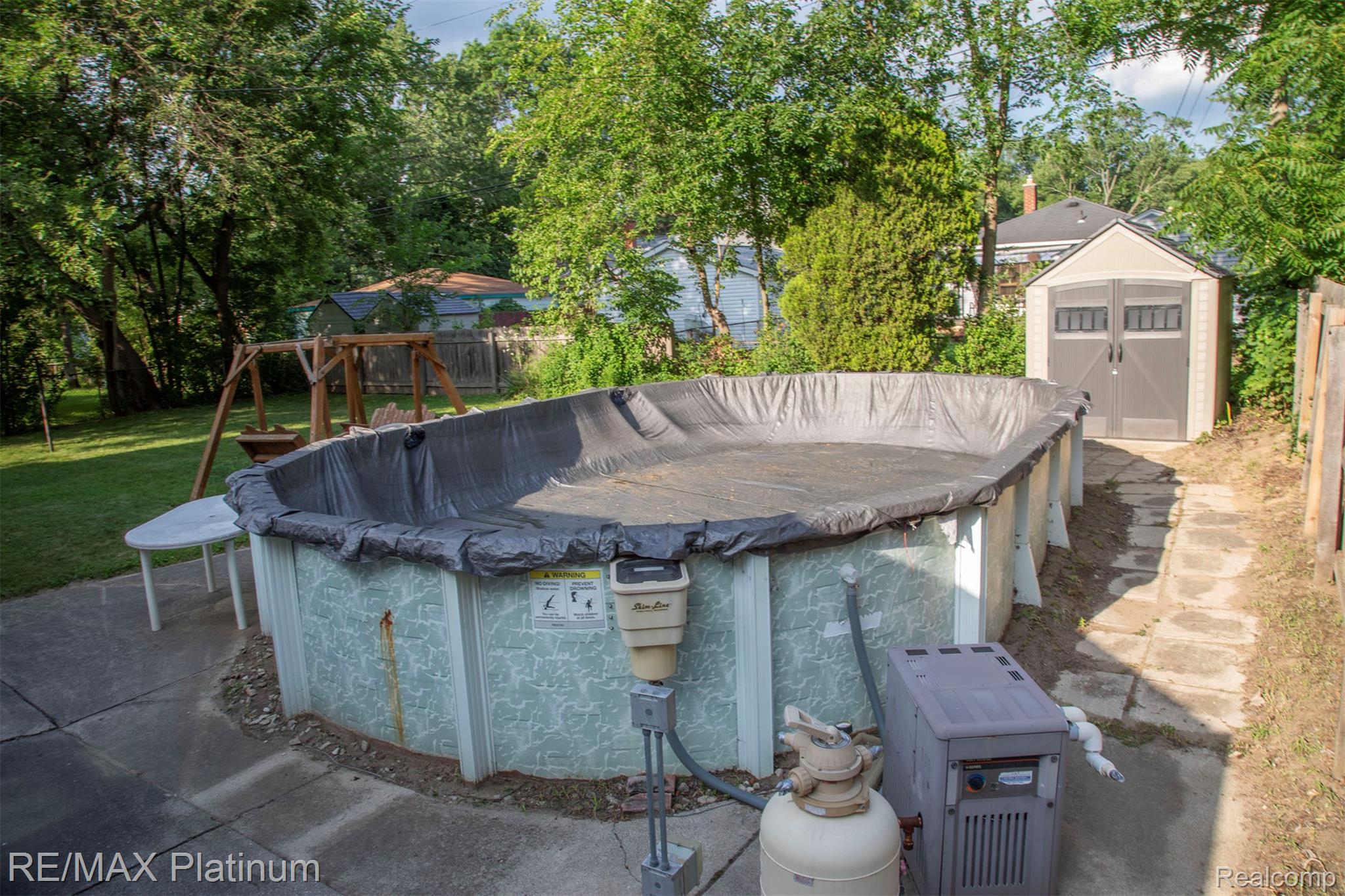 18696 Inkster Road Redford, MI 48240 - Photo 13 of 14 Backyard featuring a covered above-ground pool, a wooden playset, and a utility shed