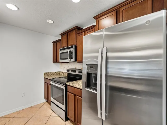 a kitchen with granite countertop stainless steel appliances and wooden cabinets