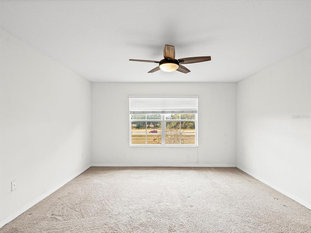 9779 Trumpet Vine Loop Trinity, FL 34655 - Photo 14 of 33 an empty room with a ceiling fan and window
