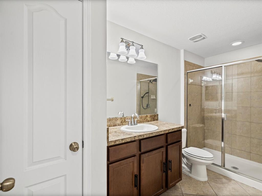 9779 Trumpet Vine Loop Trinity, FL 34655 - Photo 16 of 33 a bathroom with a toilet a sink and mirror