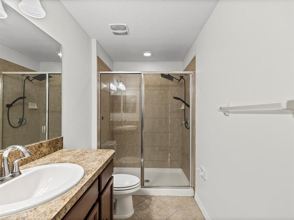 9779 Trumpet Vine Loop Trinity, FL 34655 - Photo 17 of 33 a bathroom with a granite countertop sink a toilet and shower