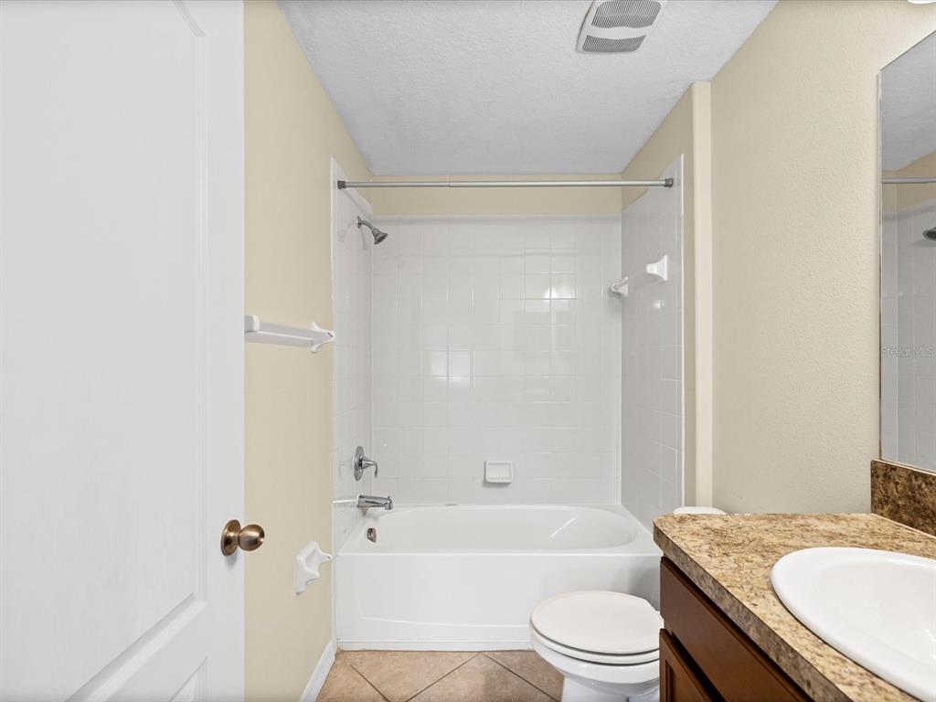 9779 Trumpet Vine Loop Trinity, FL 34655 - Photo 20 of 33 a bathroom with a granite countertop bathtub shower sink vanity mirror and toilet