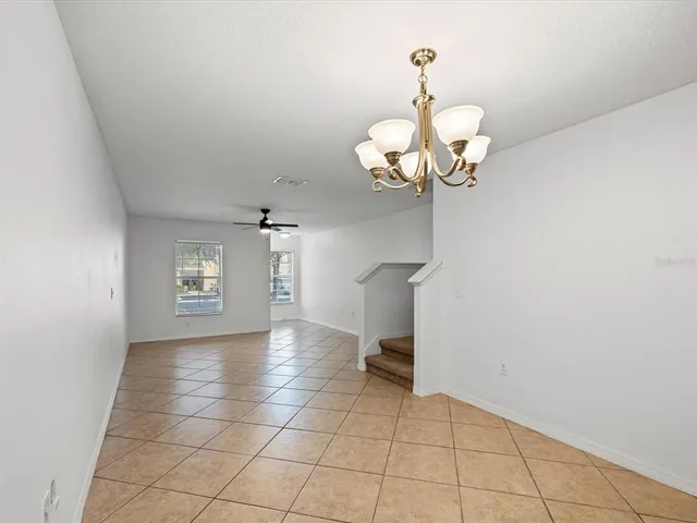 a view of a room with a chandelier fan and windows