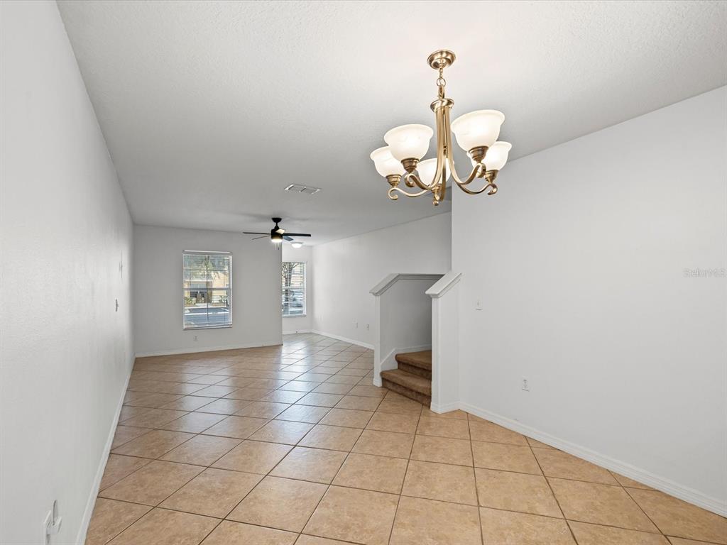 9779 Trumpet Vine Loop Trinity, FL 34655 - Photo 7 of 33 a view of a room with a chandelier fan and windows