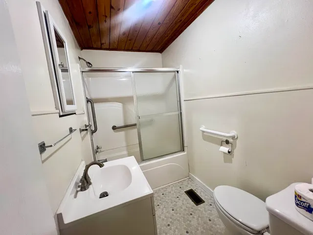 a bathroom with a sink a toilet and shower