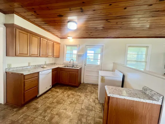 a kitchen with granite countertop a sink cabinets and window