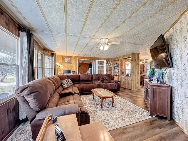 a bedroom with furniture a flat screen tv and a large window