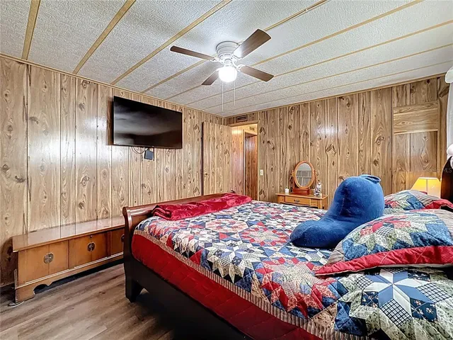 a bedroom with a large bed and wooden floor