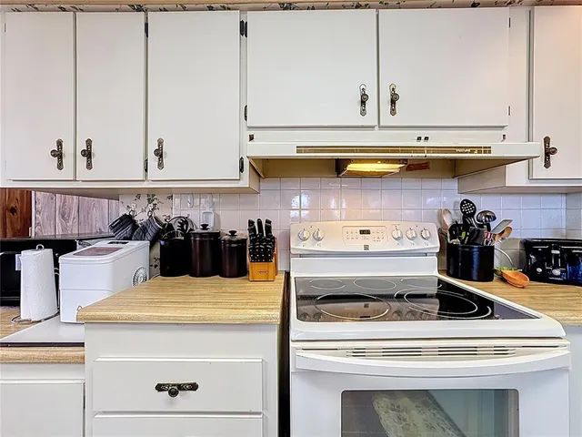 a kitchen with stainless steel appliances granite countertop a table chairs sink and cabinets