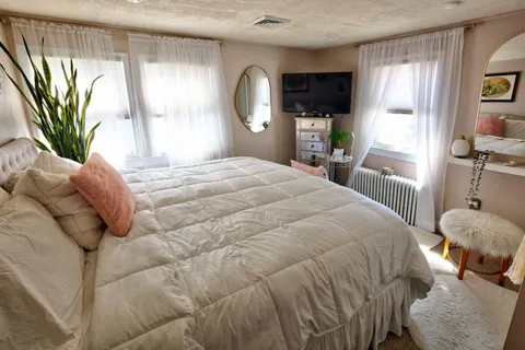 a bedroom with a bed and a large window