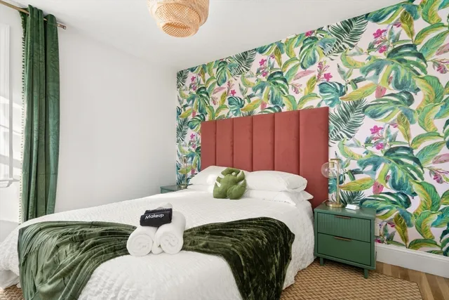 a bedroom with a bed and a painting on the wall