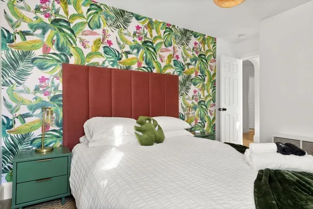 a bedroom with a bed and a painting on the wall