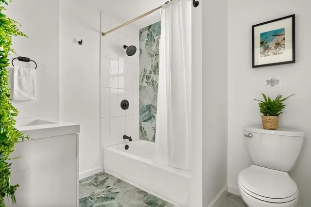 a white toilet sitting next to a bath tub shower