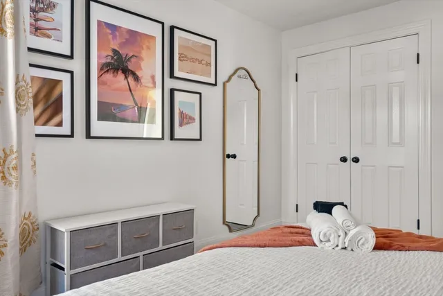 a bedroom with a bed and a painting on the wall