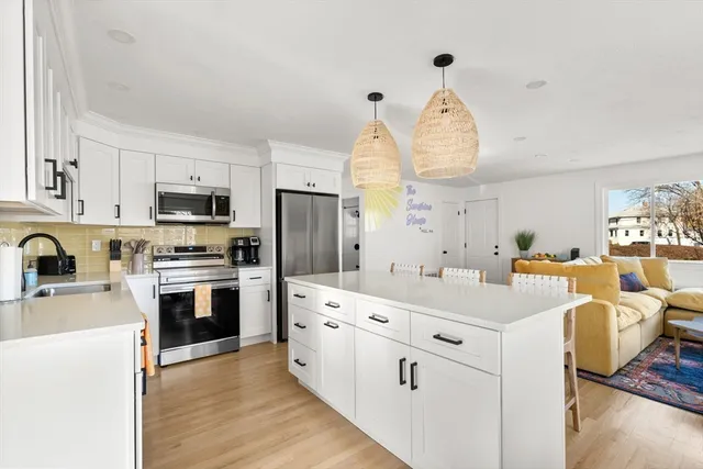 a kitchen with white cabinets and stainless steel appliances