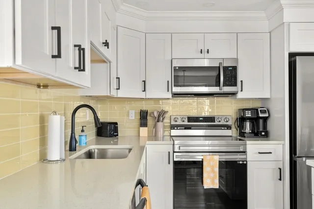 a kitchen with stainless steel appliances granite countertop a stove a sink a refrigerator and cabinets