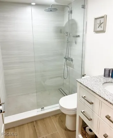 a bathroom with a granite countertop toilet sink and shower