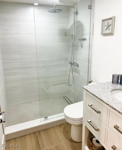 a bathroom with a granite countertop toilet sink and shower