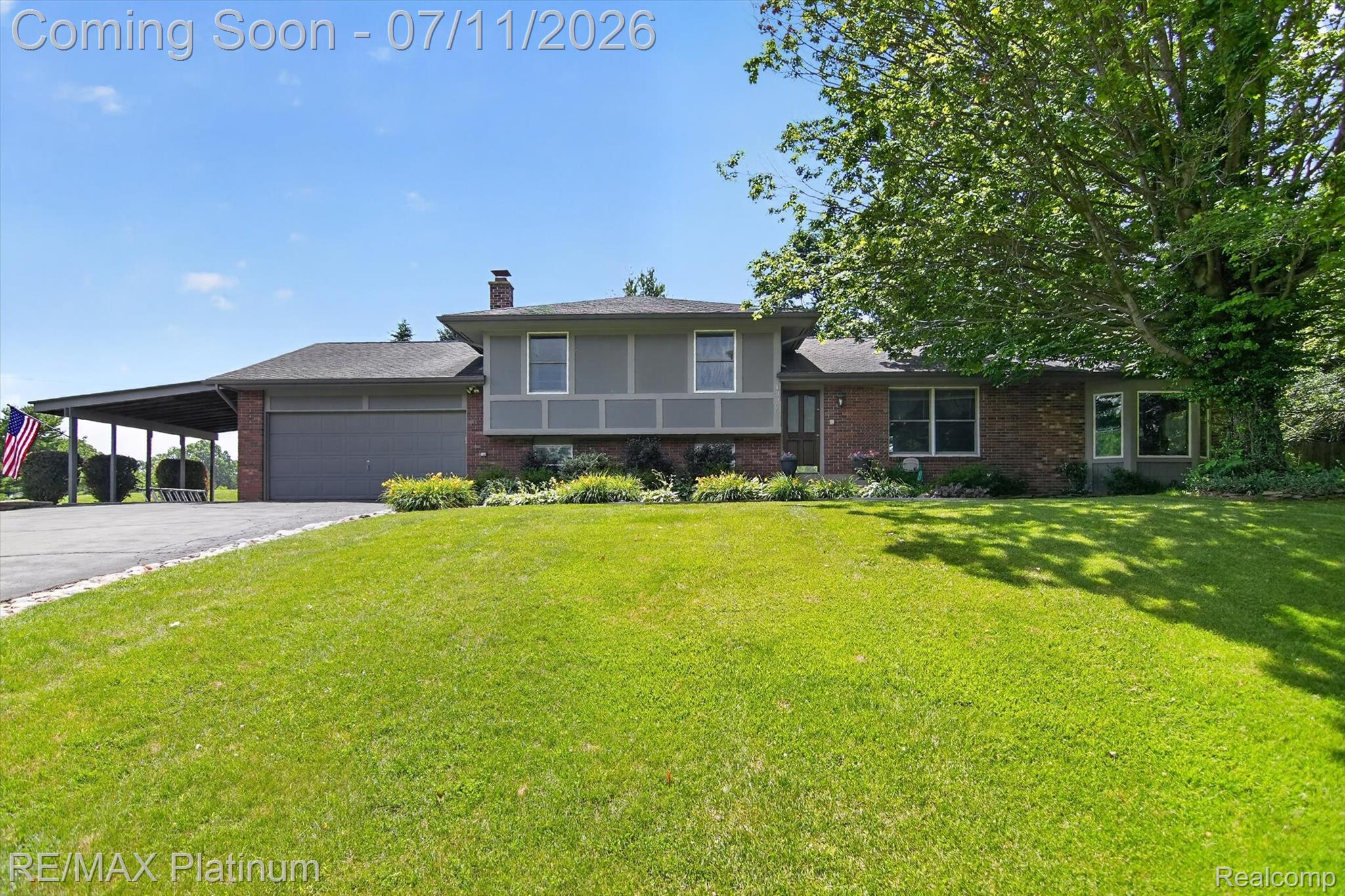 13365 North Territorial Road Gregory, MI 48137 - Photo 3 of 52 Split-level residence featuring a brick facade, gray siding, and a prominent front lawn