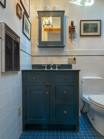 a bathroom with a sink a toilet and mirror