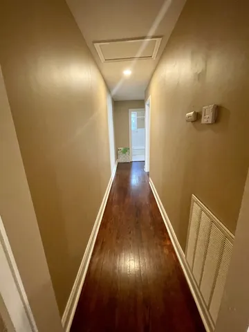 a view of a hallway with wooden floor