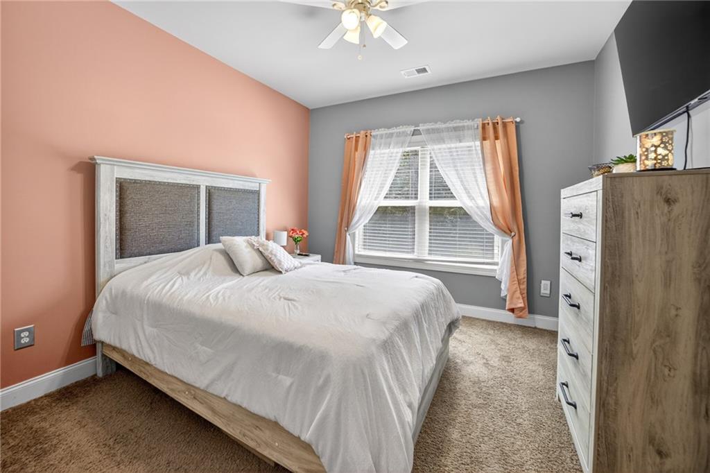 2300 Tucker Mill Road Southwest Conyers, GA 30094 - Photo 16 of 45 a bedroom with a large bed and a chandelier