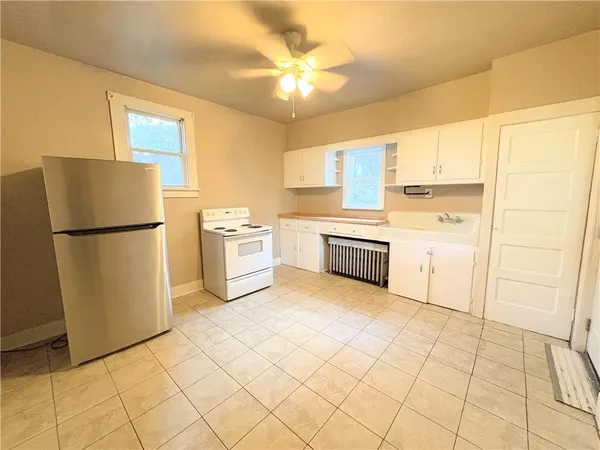 a kitchen with white cabinets and white appliances