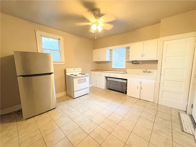 a kitchen with white cabinets and white appliances