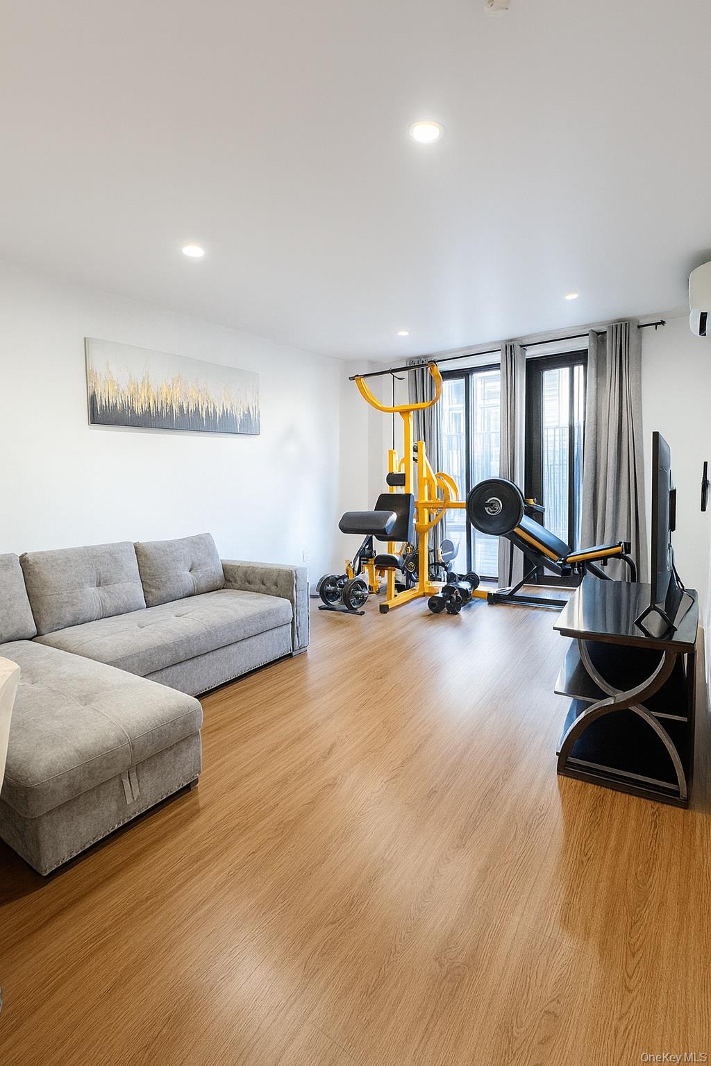 45-16 83rd Street, Unit E2D Queens, NY 11373 - Photo 6 of 11 a living room with furniture gym equipment and a large window