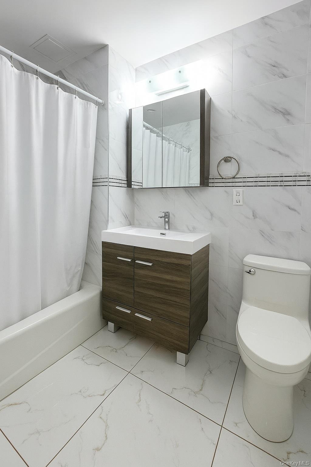 45-16 83rd Street, Unit E2D Queens, NY 11373 - Photo 9 of 11 a bathroom with a toilet a sink and bathtub