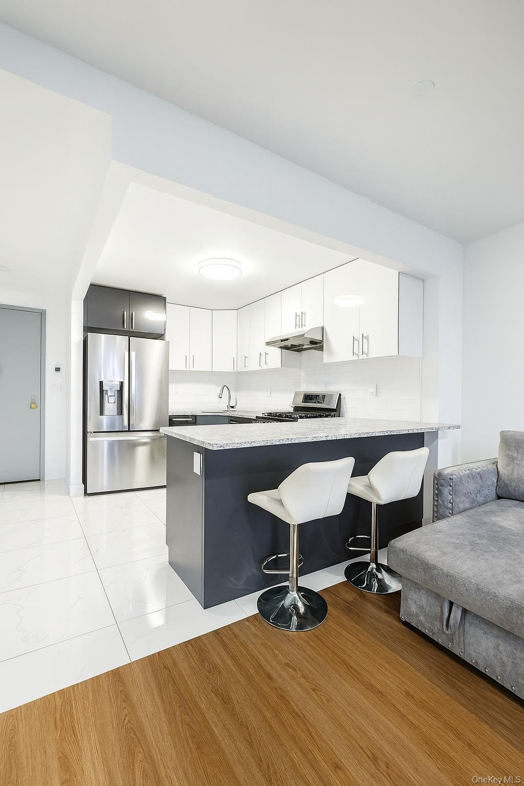 45-16 83rd Street, Unit E2D Queens, NY 11373 - Photo 10 of 11 a living room with stainless steel appliances kitchen island granite countertop furniture and a kitchen view